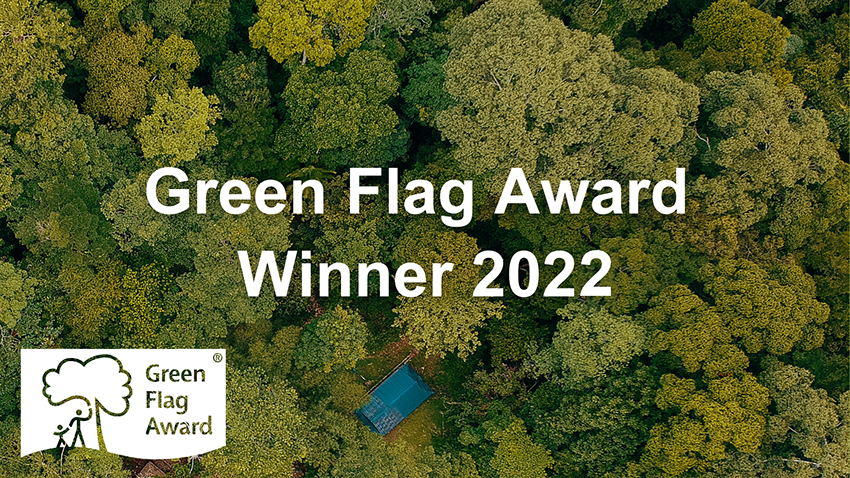 An overhead shot of a forest with the words "Green Flag Award Winner 2022" superimposed on top