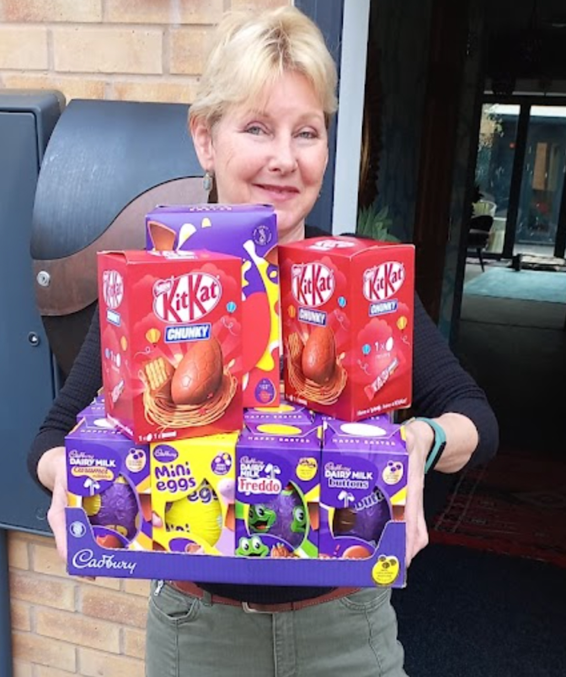 An image depicting Estelle Allam of Revival Residents Association carrying a tray of chocolate eggs