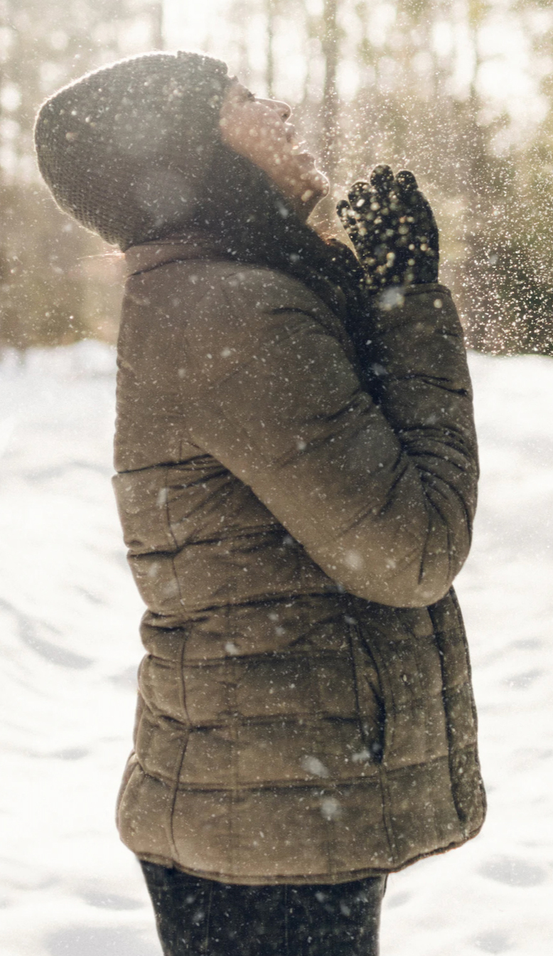 Joyful woman grasping at the snow