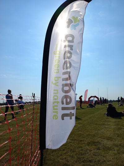 a greenbelt flag planted in the field of the northstowe running event